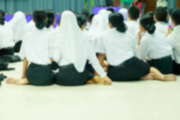 Unscharfe Studenten sitzen auf dem Boden im Besprechungsraum Rückansicht — Stockfoto