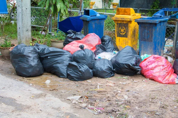 Pilha de lixo preto na beira da estrada e gotas de chuva no saco na cidade — Fotografia de Stock