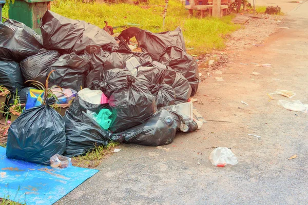 Lixo de pilha saco preto beira de estrada de plástico na cidade — Fotografia de Stock