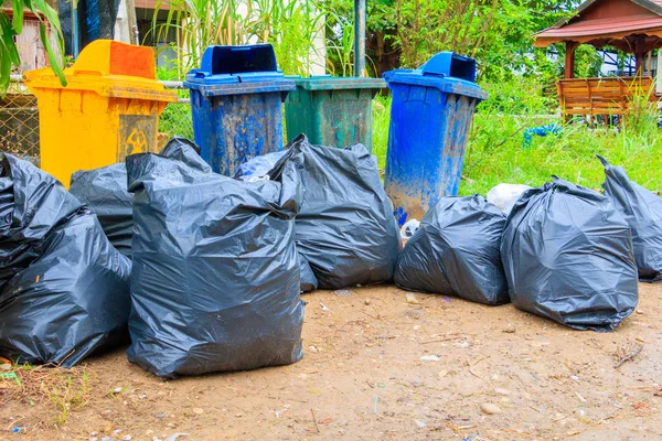Pilha de plástico saco de lixo preto e quatro lixeira beira de estrada suja — Fotografia de Stock