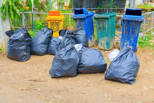 Pilha de plástico saco de lixo preto e quatro lixeira beira de estrada suja — Fotografia de Stock