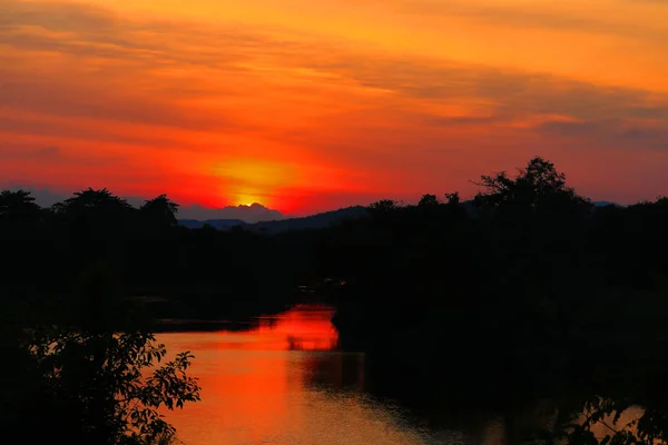Solnedgång i sky vackra färgstarka landskap och siluett träd — Stockfoto