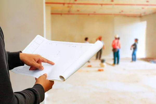 engineer finger point on paper plan blueprint in check building