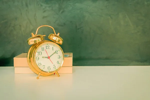 Reloj despertador viejo vintage oro y libro sobre blanco —  Fotos de Stock
