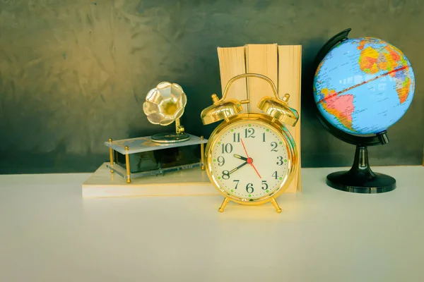 Reloj despertador viejo vintage oro y globo de plástico - libro —  Fotos de Stock