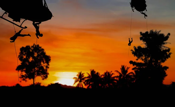 Silhouette Soldiers rappel down to attack from helicopter with sunset