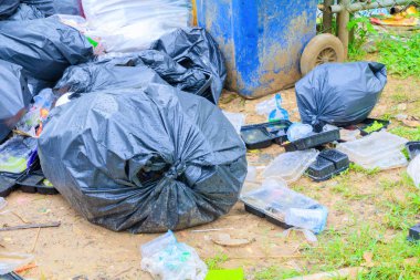 Siyah çöp yol kenarında ve yağmur damlaları çanta üzerinde kazık