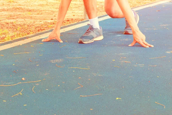 Arm male touch floor start pose training running on track rubber — Stock Photo, Image