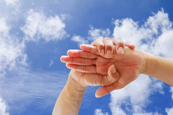 Jóvenes que unen sus manos en el fondo azul del cielo — Foto de Stock