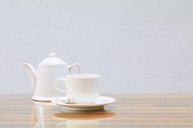 kahve fincanı ve çaydanlık beyaz cam masa ahşap ve çimento duvar arka plan