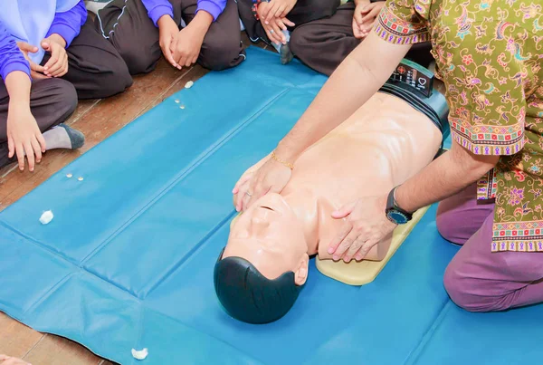 Mano estudiante bomba de corazón con maniquí médico en la RCP, en el entrenamiento de actualización de emergencia — Foto de Stock