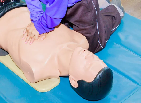Mano estudiante bomba de corazón con maniquí médico en la RCP, en el entrenamiento de actualización de emergencia — Foto de Stock