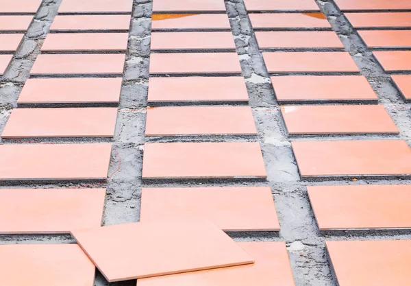 row tile ceramic orange on floor install with cement