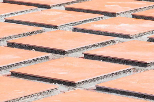 row tile ceramic orange on floor install with cement