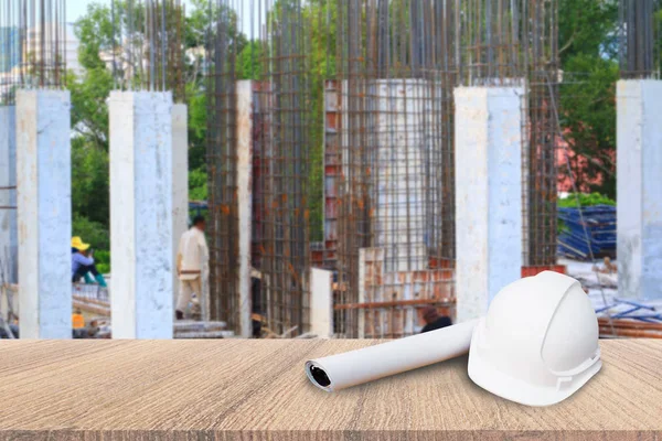 Sombrero de seguridad blanco y plano de papel plano sobre mesa de madera en obra — Foto de Stock
