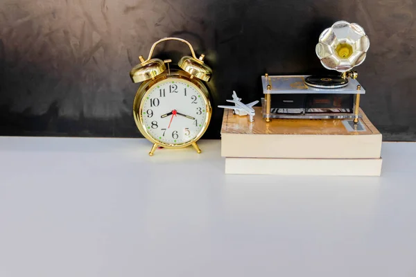 Reloj despertador viejo vintage oro y globo de plástico - libro, plano sobre blanco sobre fondo negro —  Fotos de Stock