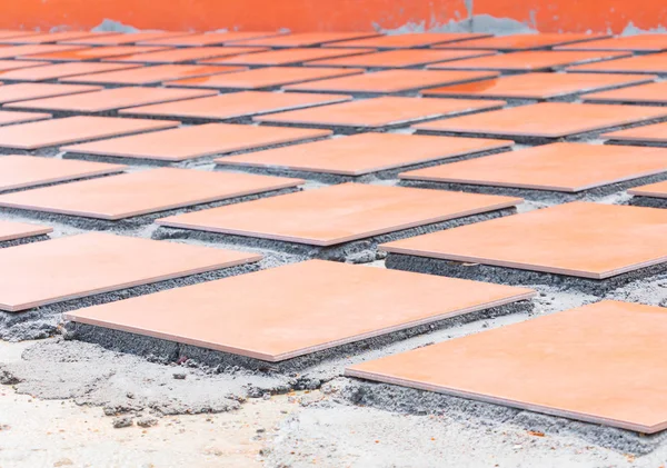 row tile ceramic orange on floor install with cement in work construction