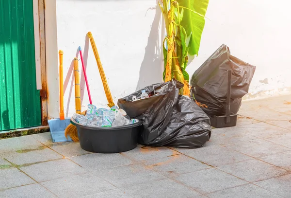 Műanyag szemetes táska. Bolyhos, fekete szemét a padlón az épületfal mellett — Stock Fotó