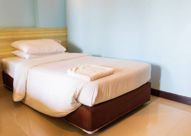 yatak odasında yatak ve yatak örtüsü yastık beyaz