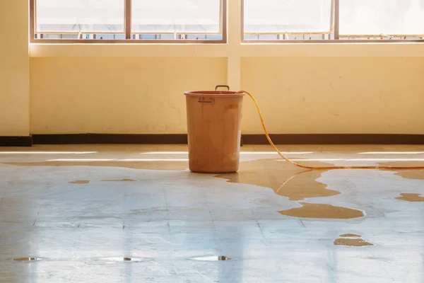 Water leak drop interior office building in red bucket — Stock Photo, Image