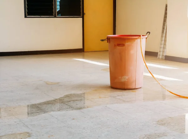 water leak drop interior office building in red bucket