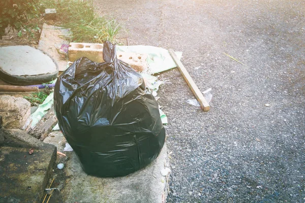 Plastikowej torby na śmieci. Pile czarny śmieci drogowych — Zdjęcie stockowe