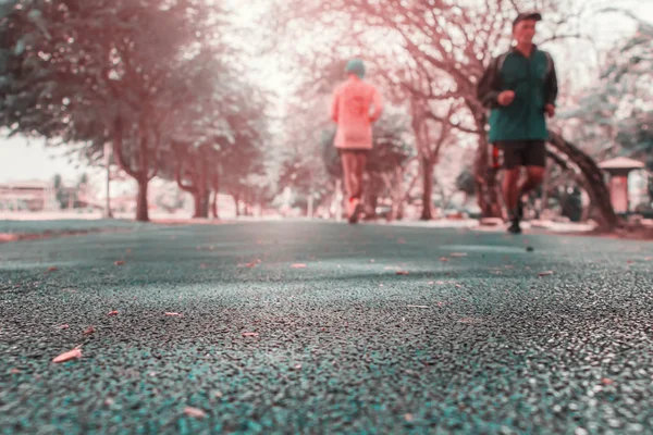 Piste courir couverture en caoutchouc bleu dans le parc public exercice de jogging pour la santé et flou coureur — Photo