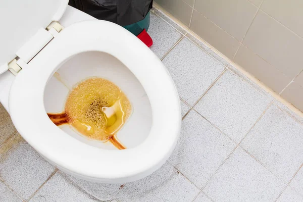 Vaso sanitário tigela branca cerâmica cheia de urina na sala de banheiros público — Fotografia de Stock