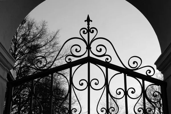 black and white photo of an old iron gate