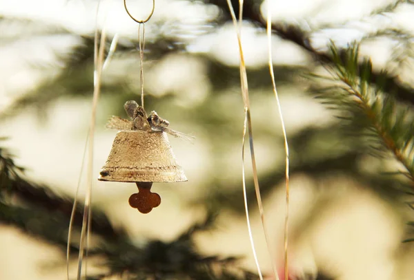 small silver bell hanging on the christmas tree