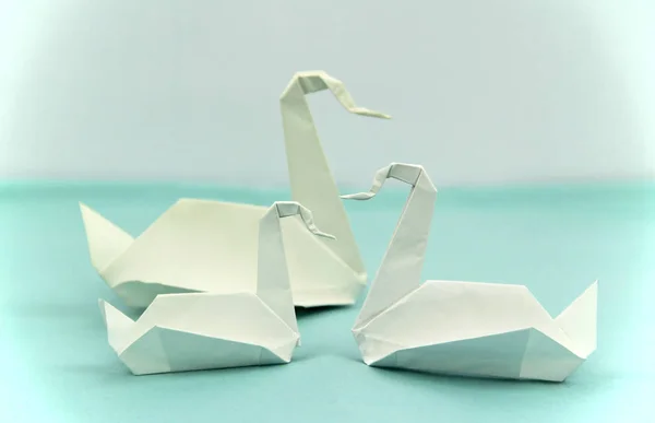 three origami paper swans of various sizes together, family concept