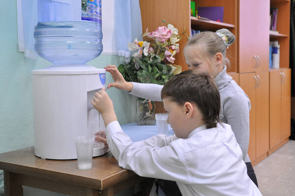 Дети собирают воду из холодильника
