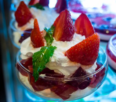 Kafede tezgahta duran kremanke krem şanti ile Çilek