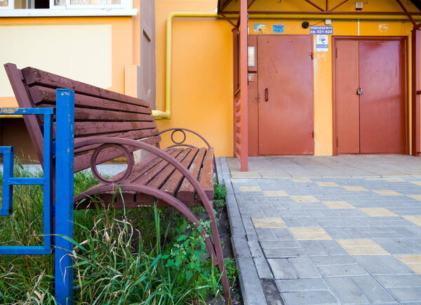 Новая скамейка у входа в современное жилое здание
