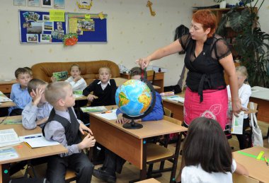 Murmansk, Rusya - 17 Eylül 2013, Globe kullanarak sınıfta coğrafya okuyan çocuklar