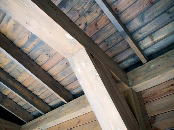 Wooden support beam and roof lathing riveted to it