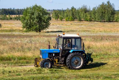 Zadonsk, Russia - August 22, 2018: Tractor rides on the edge of a field in the countryside