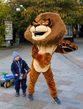Yalta, Kırım - 08 Kasım 2015: Yalta şehrinde çocukları eğlendiren aslan kostümlü animasyon sanatçısı