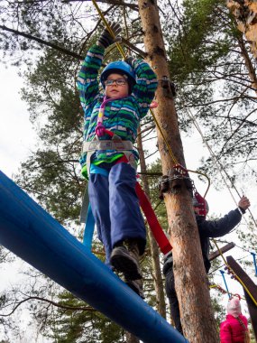 Sosnovy Bor, Rusya - 19 Mart 2016: Turist kulübünde askıya alınmış sınıfların üzerinde yürüyen çocuk