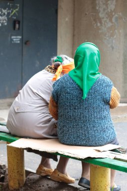 Jartcevo, Rusya - 24 Ağustos 2010: İki dedikoducu büyükanne bankta ve girişte oturan