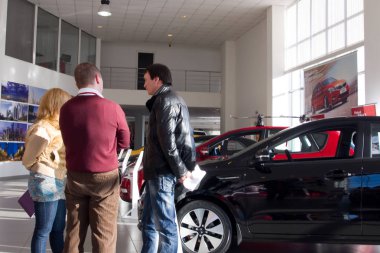 Murmansk, Rusya - 21 Mart 2012: İnsanlar showroom'da yeni araçların yanında duruyor