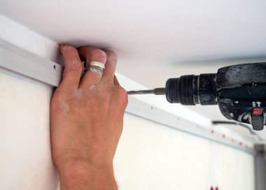 Usta duvara streç tavan için baget bağlar