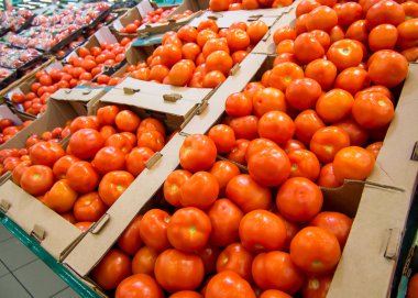Süpermarket tezgahındaki kutularda taze domatesler