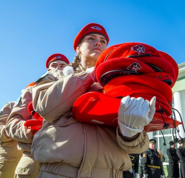 Murmansk, Russia - April 22, 2019: The cadets carry in their hands piles of uniform berets for initiation into the Unarmeitsa clipart