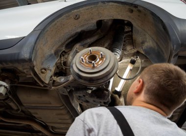 Voronezh, Russia - May 30, 2019: Checking shock absorbers of a car by a car service master clipart