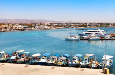 Paphos, Kıbrıs - 24 Temmuz 2019: limanda balıkçı tekneleri ve yatlar. Tatil köyünün gezinti alanı manzarası