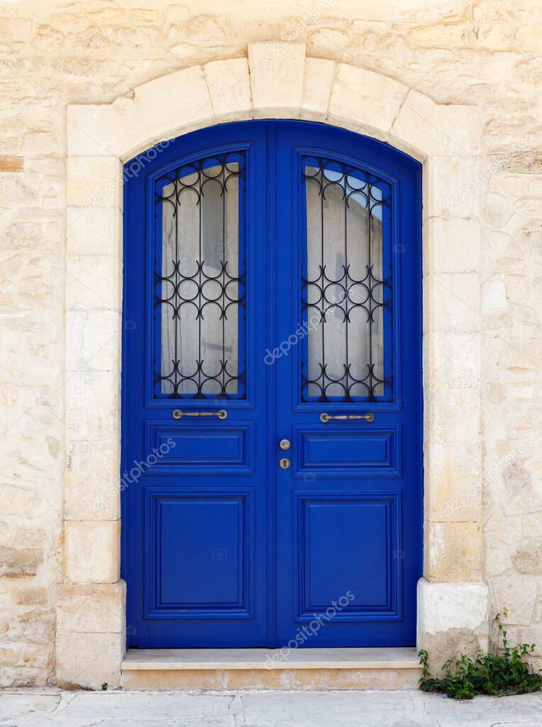 Beautiful old door in dark blue. Fragment of the facade of a Sandstone house, Cyprus, Europe