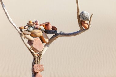 Kum arka planındaki kuru bir çıkmazda taşların dengesi. Uyum, denge ve meditasyon kavramı. Yumuşak odaklanma, seçici odaklanma, uzayı kopyalama. Yumuşak odaklı, seçici odaklı