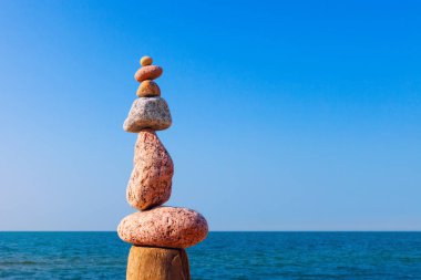 Denge ve denge taşları. Mavi gökyüzü ve denizin arka planında Rock zen