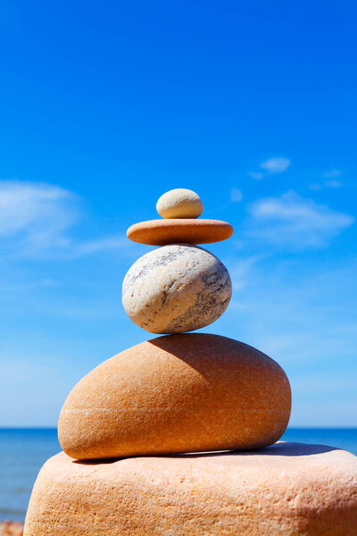 Stones balance on a background of blue sky and sea. Concept of balance and harmony. Rock zen